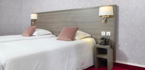 Cama ou camas em um quarto em Hôtel De France