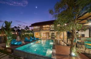 eine Villa mit einem Pool und einem Haus in der Unterkunft Kubu Tropis in Ubud