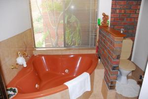 baño con bañera roja y pared de ladrillo en Gaerwood B&B en Keith