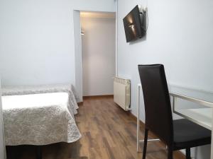 Zimmer mit einem Bett, einem Schreibtisch und einem Stuhl in der Unterkunft Hostal Lesseps in Barcelona