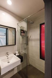 a bathroom with a sink and a glass shower at TOBEDzZ HOTEL in Ranong