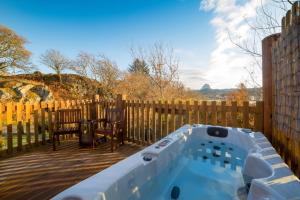 bañera de hidromasaje en una terraza junto a una valla de madera en Suilven view en Lochinver