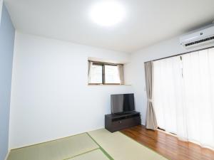 Il comprend un salon doté d'une télévision et d'une fenêtre. dans l'établissement Maruka石垣島, à Ishigaki