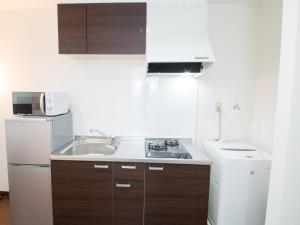 a small kitchen with a sink and a refrigerator at Maruka石垣島 in Ishigaki Island