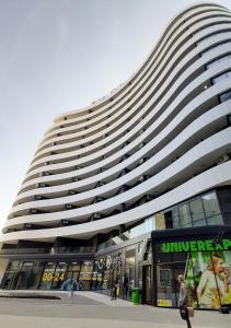 Un gran edificio con gente caminando frente a él. en Central Palace Apartmani - Pupinova palata, en Novi Sad