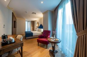 een hotelkamer met een bed en een rode stoel bij Nova Plaza Pera in Istanbul