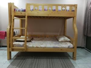 a wooden bunk bed with a ladder and a pillow at D-Toys Homestay in Khon Kaen
