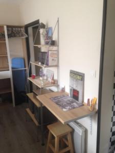 a room with a table and shelves in a room at Studio très confortable in Limoges