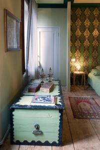 uma sala com um baú com livros em La Maisonette em Feltre
