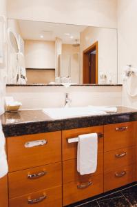 a bathroom with a sink and a large mirror at Ringhotel Teutoburger Wald in Tecklenburg