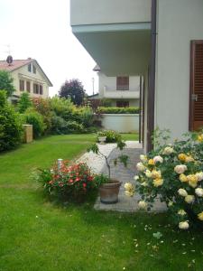 a garden with flowers in a yard next to a house at Anne's House in San Giuliano Terme