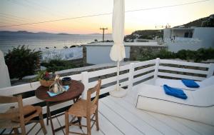 a balcony with a table and chairs and a view of the ocean at Mykonos Moussa in Agios Ioannis Mykonos