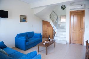 a living room with a blue couch and a table at Manoleas Villas - Apartment 4 in Stoupa