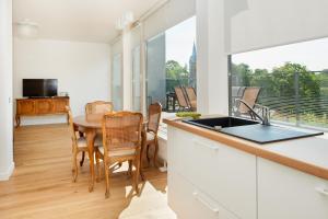 Una cocina y un comedor con mesa y sillas. en Central Apartment, en Birštonas