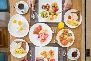 a table with plates of breakfast food on it at Paris Deli Danang Beach Hotel in Danang