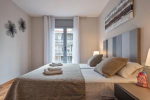 a bedroom with a large bed with two towels on it at Alcam Hercules in Barcelona