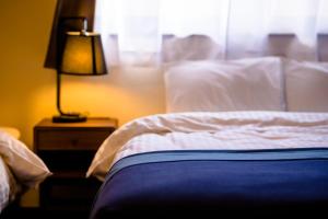 a bedroom with a bed and a lamp on a night stand at ID-STAY河口湖Ⅲ in Fujikawaguchiko