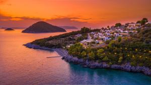 an island in the ocean at sunset at Adrina Resort & Spa in Panormos Skopelos