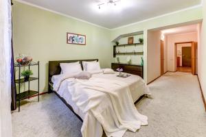 1 dormitorio con 1 cama grande con sábanas blancas en Апартаменты Веста на Фонтанке, en San Petersburgo