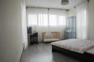 VolzhskiyにあるHoliday home Shvedskie Dachiのベッドルーム1室(ベッド1台、デスク、窓付)