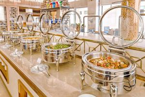 a row of food pans on a counter in a kitchen at Paris Deli Danang Beach Hotel in Danang