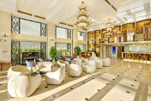 a large living room with white chairs and a chandelier at Paris Deli Danang Beach Hotel in Danang