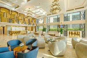 a lobby with chairs and tables and windows at Paris Deli Danang Beach Hotel in Danang