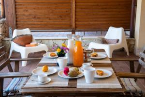 uma mesa de madeira com pratos de comida e sumo de laranja em Riva Sea Apartments em Castellammare del Golfo
