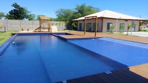 a large blue swimming pool with a playground at Condomínio Residencial Tranquilidade na Beira do Rio in Paulo Afonso