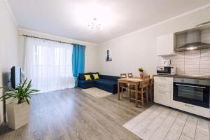 una cucina e un soggiorno con divano blu di SC Apart Ostrovskogo 93Б in Perm a Perm