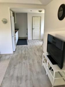ein leeres Wohnzimmer mit einem Flachbildfernseher in der Unterkunft Rymlig lägenhet i avdelat hus med egen parkering in Käglinge