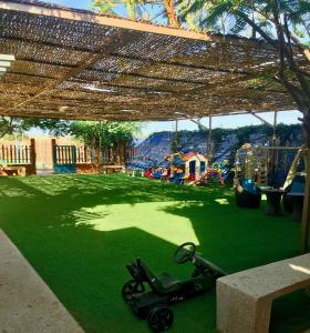 a scooter parked on the grass under a canopy at La Taniere Villa Metsu in Saly Portudal