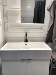 ein Badezimmer mit einem weißen Waschbecken und einem Spiegel in der Unterkunft Rymlig lägenhet i avdelat hus med egen parkering in Käglinge + 18 Fotos