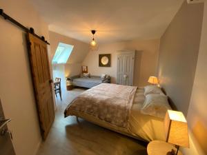 een slaapkamer met een bed, een bank en een tafel bij Chez Mary Elise in Le Claux