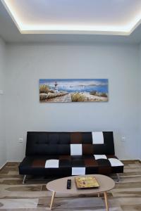 ein Wohnzimmer mit einem schwarzen Sofa und einem Tisch in der Unterkunft Ante Portum Lepanto in Nafpaktos