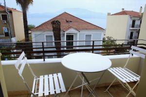 einen Balkon mit 2 Stühlen und einem weißen Tisch in der Unterkunft Ante Portum Lepanto in Nafpaktos