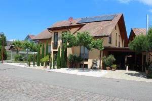 uma casa com painéis solares do lado de uma rua em Pension Vanii, Apartments em Rust