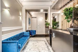 un divano blu in una sala d'attesa con piante di Hotel 55 Fifty-Five - Maison d'Art Collection a Roma