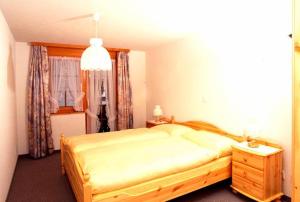 a bedroom with a large bed and a window at Castel Appartemente in Saas-Grund