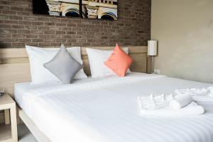 a bedroom with a white bed with colorful pillows at Chinotel - SHA Plus in Phuket Town