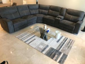 a living room with a leather couch and a table at Obhur Residence 2 in Obhor