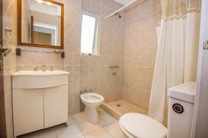 een badkamer met een toilet, een wastafel en een spiegel bij La Casona de Valeria in Valeria del Mar +13 foto's