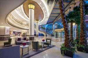 a lobby of a hotel with palm trees at Yun-Zen Jinling World Trade Plaza Hotel in Shijiazhuang
