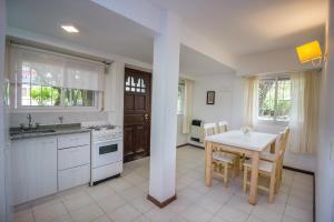 een keuken met een tafel en een tafel met stoelen bij La Casona de Valeria in Valeria del Mar