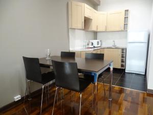 a kitchen with a table and chairs and a refrigerator at Ramada Hotel & Suites by Wyndham Alabuga in Yelabuga