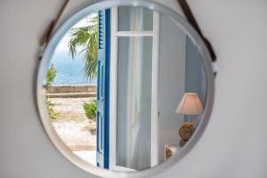 espejo que refleja una habitación con vistas al océano en Aigeis-milos, en Agia Kiriaki Beach