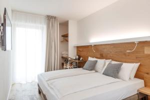 a bedroom with a large white bed and a window at ALEA - Garda Lake Suite in Arco