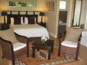 a bedroom with a bed and two chairs and a table at Paradiso Guesthouse & Self-catering Cottage in Cape Town