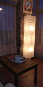 uma mesa com uma tigela e uma lâmpada sobre ela em Casa Rural La Guapeta em Ademuz