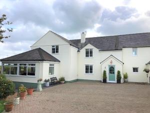 una grande casa bianca con un grande vialetto di Frongaer Bed And Breakfast a Llanerchymedd